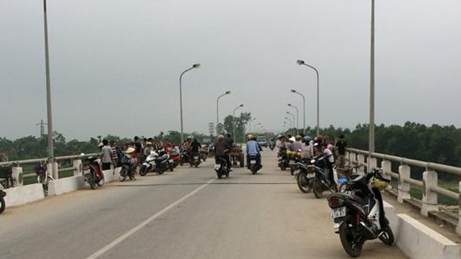 Nhiều người dân hiếu kỳ tập trung tại cầu Đô Lương, nơi nam thanh niên đã nhảy sông tự vẫn - Ảnh: Người Lao Động