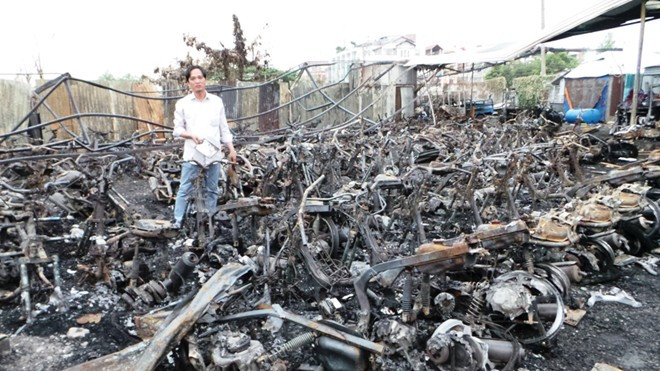 Anh Nhân đứng giữa hàng trăm xe tay ga bị cháy rụi trong vụ hỏa hoạn. 