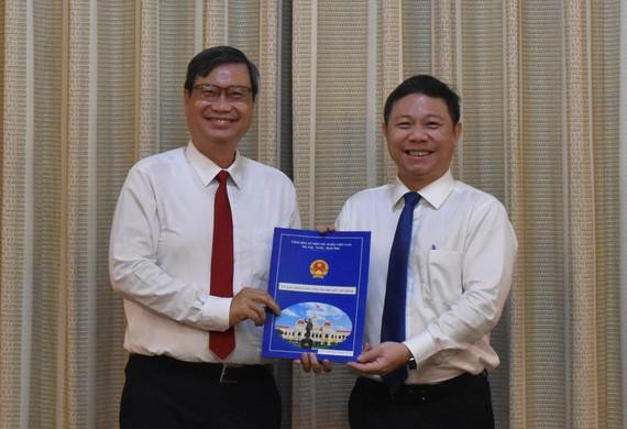 Ông Vương Đức Hoàng Quân (trái) nhận quyết định điều động của UBND TPHCM. Ảnh: Đình Lý