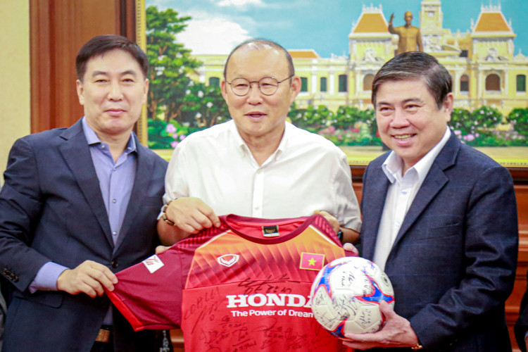 Huấn luận viên Park Hang Seo tặng quà lưu niệm cho Chủ tịch UBND TP HCM Nguyễn Thành Phong. Ảnh: Hữu Nguyên.