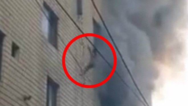 Hình ảnh em bé được thả từ tầng 4 xuống (trong khoanh đỏ) khiến không ít người thót tim. 