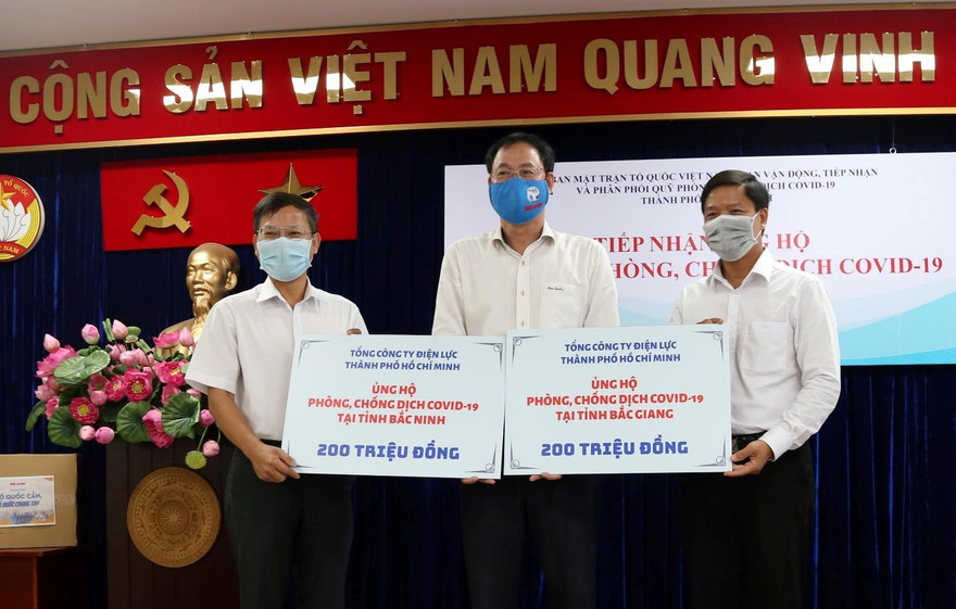 Ông Lê Văn Minh - Chủ tịch Công đoàn (phải) và ông Phạm Việt Anh – Phó trưởng Ban Truyền thông (trái) đại diện EVNHCMC trao 400 triệu đồng ủng hộ 2 tỉnh Bắc Giang, Bắc Ninh phòng chống dịch Covid. Ảnh: Chi Lan 