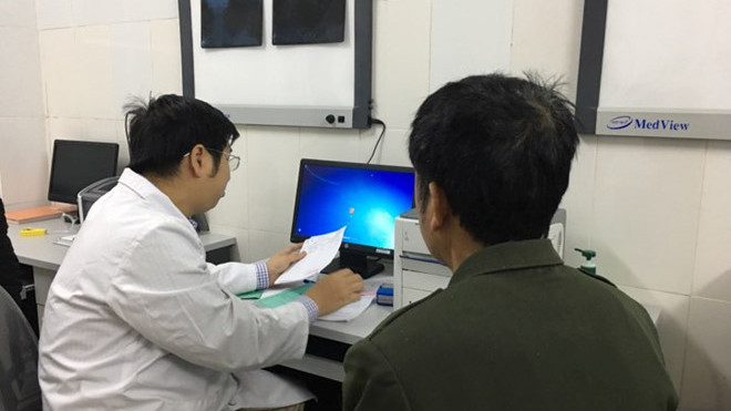 Bác sĩ Nguyễn Trần Trung khám bệnh cho bệnh nhân gout. Ảnh: HQ.