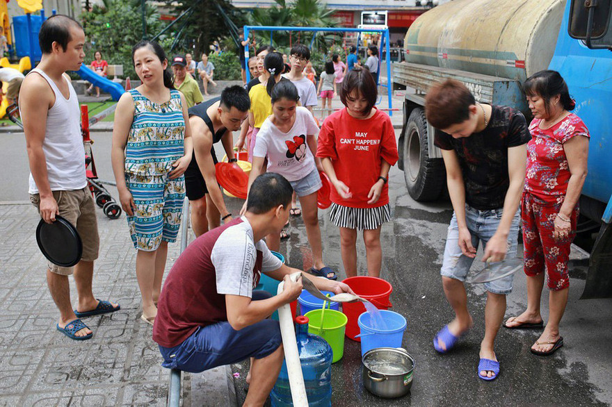 Người dân Linh Đàm, Hà Nội xếp hàng lấy nước sạch từ xe tec nước chở đến. Ảnh: như ý 