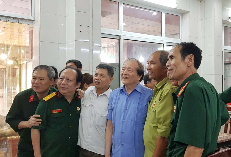 Nhà thơ Hữu Thỉnh (thứ 3 từ phải sang) bên những cựu binh xe tăng tại lễ ra mắt cuốn sách “Theo vết xích xe tăng” tập 3. Ảnh: KIẾN NGHĨA