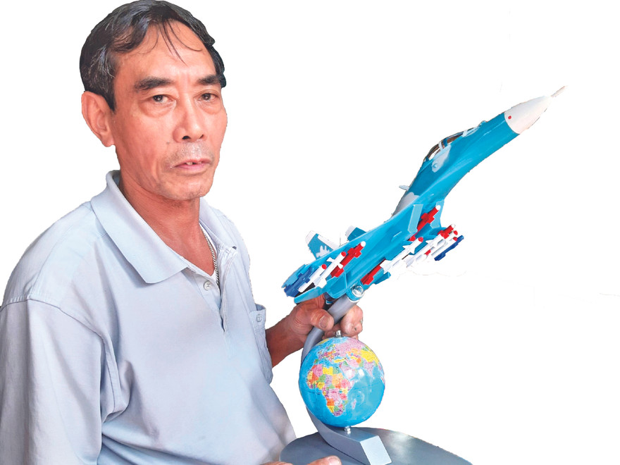 Ông Bùi Xuân Thành với chiếc máy bay chiến đấu mô hình đã hoàn thành Ảnh: Nguyễn Thành