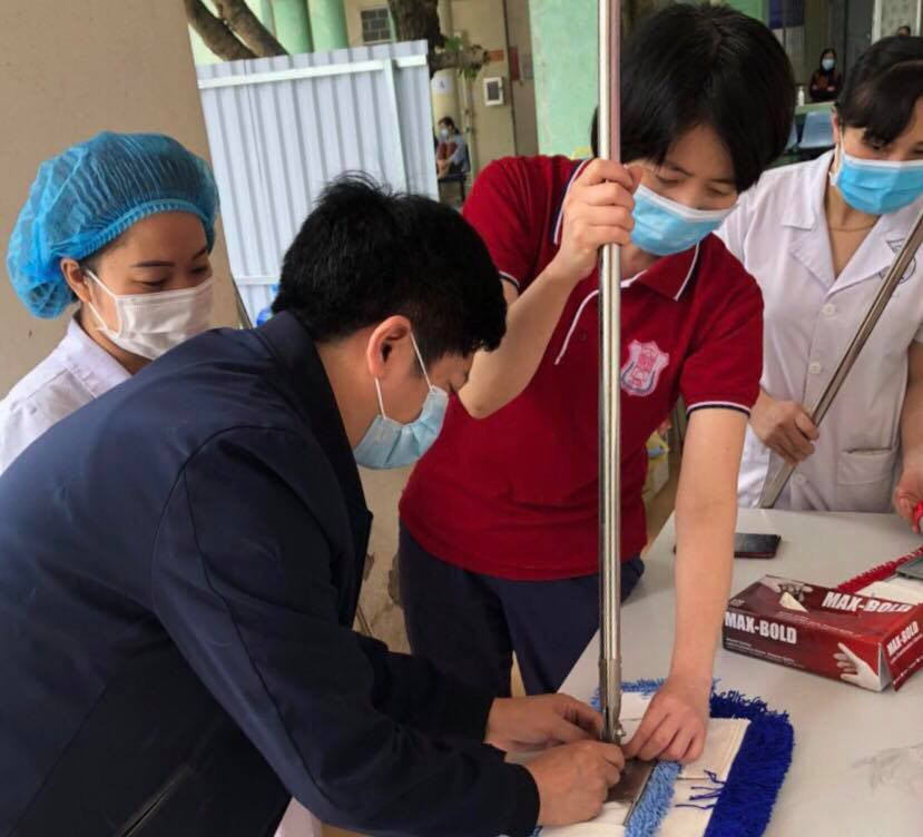 Bác sĩ Thư (thứ 2 phải sang) và bác sĩ Khoa hướng dẫn nhân viên y tế sử dụng thiết bị làm sạch bề mặt