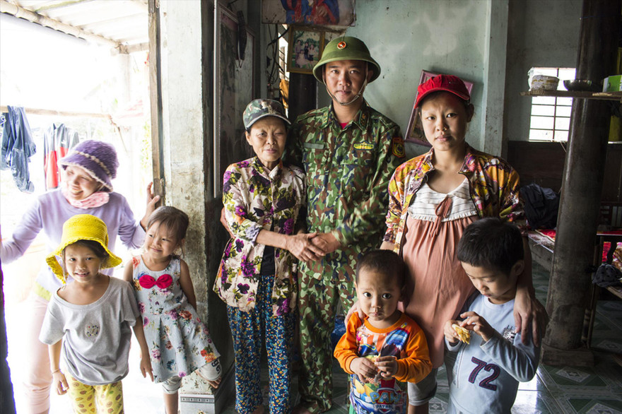 Gia đình bà Dương Thị Doát, trong đó có một thai phụ được biên phòng Ngư Thủy cứu sống khi cả nhà đang ngồi trên chiếc giường treo. Ảnh: Văn Chương