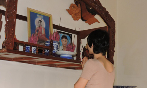 Bà Tâm thắp nén nhang cho người chồng quá cố