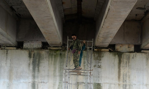 Công nhân sửa chữa cầu chui bị thấm, dột nước. Ảnh: N.T 