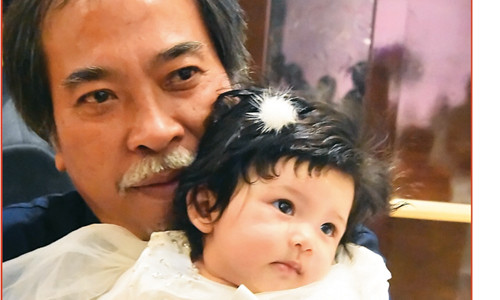 Nhà thơ Nguyễn Quang Thiều và cháu ngoại Ảnh: Nguyễn Đình Toán 