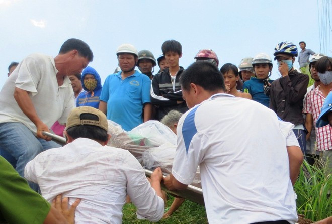 Đưa nạn nhân lên bờ khám nghiệm tử thi. Ảnh: Zing.vn