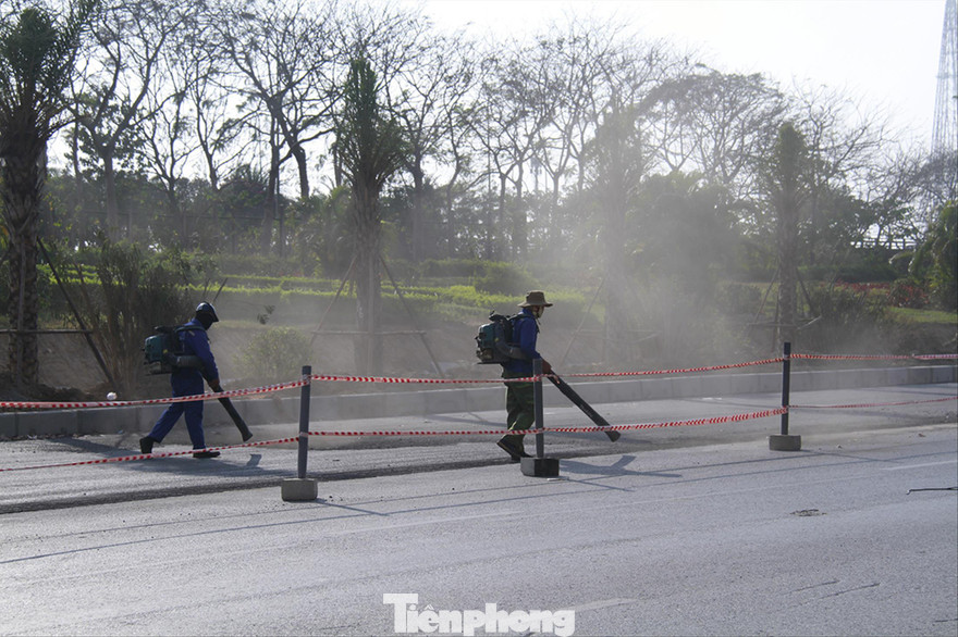 Dùng máy thổi bụi tại khu vực thi công ở đại lộ Thăng Long. Ảnh: Trường Phong