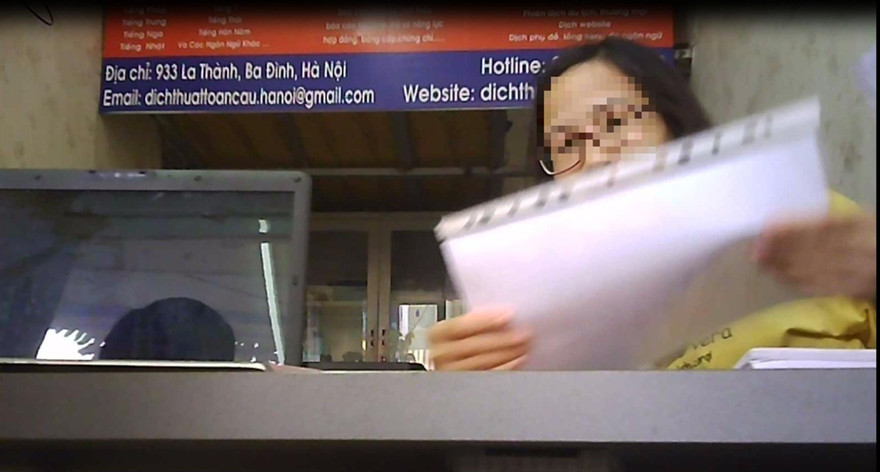 Nhân viên của một trung tâm dịch thuật nhận công chứng giấy tờ không cần bản gốc (ảnh cắt từ clip) 
