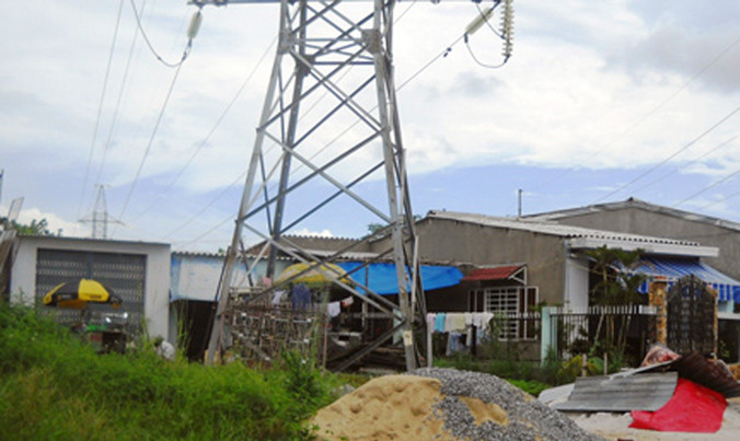 Người dân làm nhà và sinh sống ngay dưới đường dây 220 kV vi phạm hành lang an toàn lưới điện cao thế nghiêm trọng. Ảnh: HL.