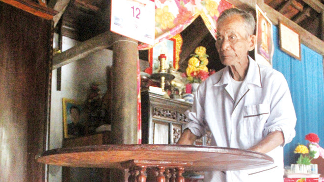 Nghệ nhân Đinh Thạch bên chiếc bàn xoay do cụ chế tác. Ảnh: H. Văn.