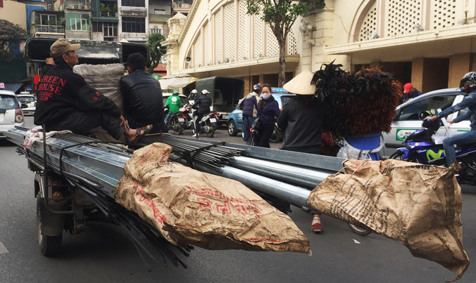 Xe ba bánh chở vật liệu kim loại trên phố đi bộ quanh chợ Đồng Xuân (Hoàn Kiếm, Hà Nội). Ảnh: Nguyễn Hoàn.