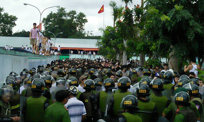 Các học viên leo lên tường, trong khi hàng trăm học viên khác đang đối đầu với công an tại trung tâm cai nghiện Đồng Nai ngày 6/11/2016. Ảnh: Anh Tuấn.