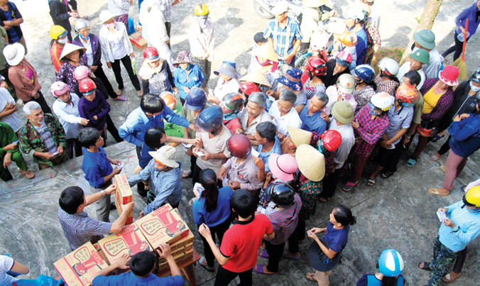 Bà con vùng rốn lũ Quảng Bình nhận quà cứu trợ. Ảnh: Trường Phong.