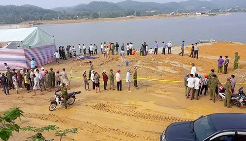 Nhiều người tập trung trên bờ xem khám nghiệm hiện trường. Ảnh: Đ.H. 