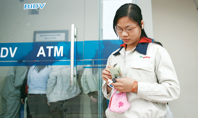 Công nhân khu công nghiệp rút tiền lương, thưởng dịp Tết 2016. Ảnh: Như Ý.