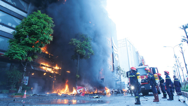Ngọn lửa bao trùm ít nhất 4 căn nhà. Lực lượng cứu hỏa cố gắng khống chế đám cháy. Ảnh: Thanh Hà.