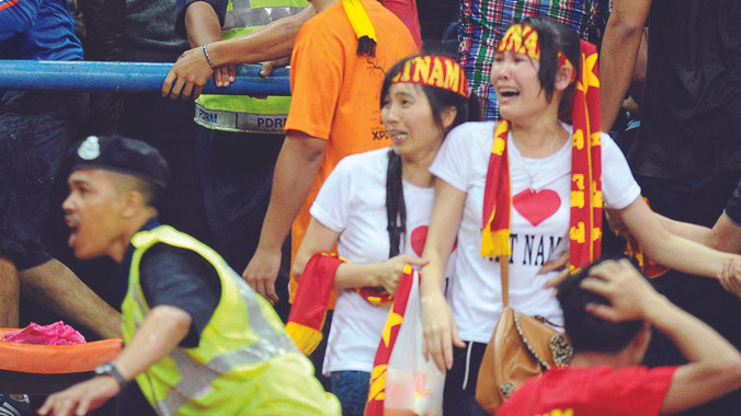 CĐV hoảng sợ, cần tới sự bảo vệ của cảnh sát ở trận bán kết lượt đi trên sân Shah Alam. Ảnh: Quang Trung 