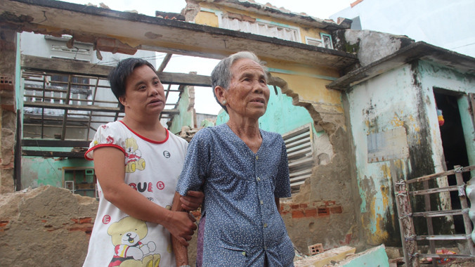 Mẹ con bà Tòng với đống đổ nát sau bão. Ảnh: Hoài Văn