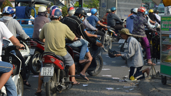 Ông Lương xin tiền tại ngã ba trước khu công nghiệp Tân Bình. Ảnh: Ngô Bình