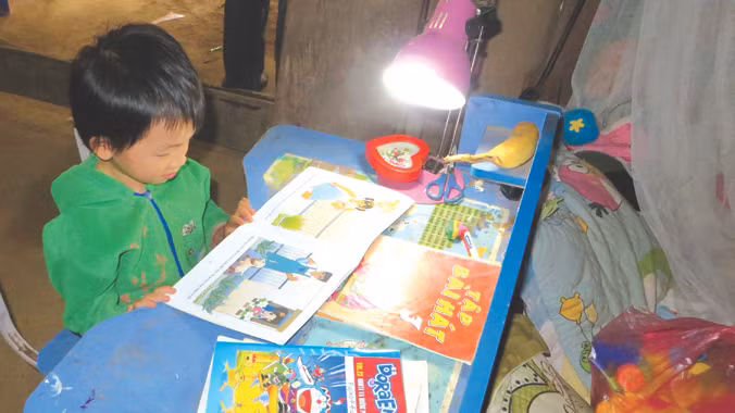 Trẻ em Nà Ròn được học tập dưới ánh đèn. Ảnh: Quỳnh Nga