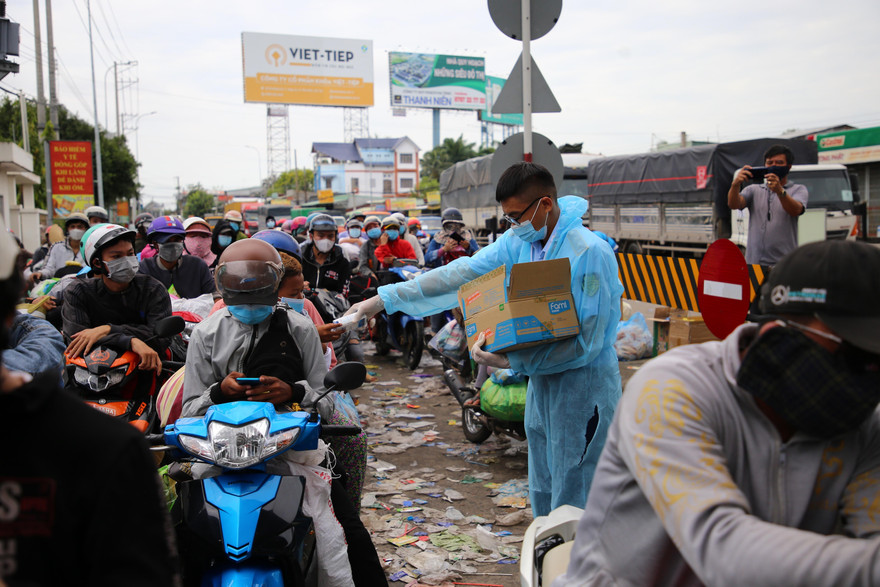 Lực lượng chức năng An Giang phát cơm, nước uống miễn phí cho người dân trong thời gian chờ địa phương bố trí vào khu vực tiếp nhận tạm thời