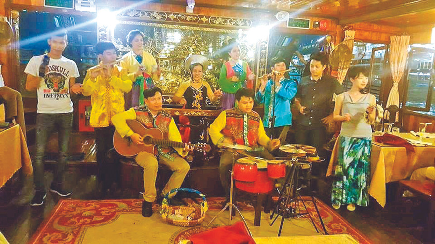 Tác giả bài viết đánh đàn ghi ta trên thuyền phục vụ khách du lịch trên sông Sài Gòn 