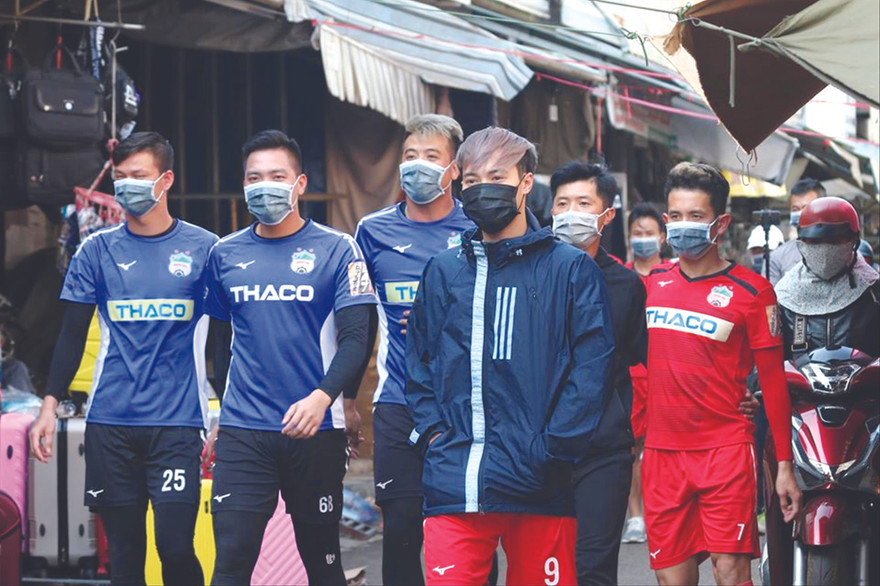 Các cầu thủ HAGL phát khẩu trang miễn phí cho người dân ở chợ​trung tâm TP​Pleiku. Ảnh: HAG ​