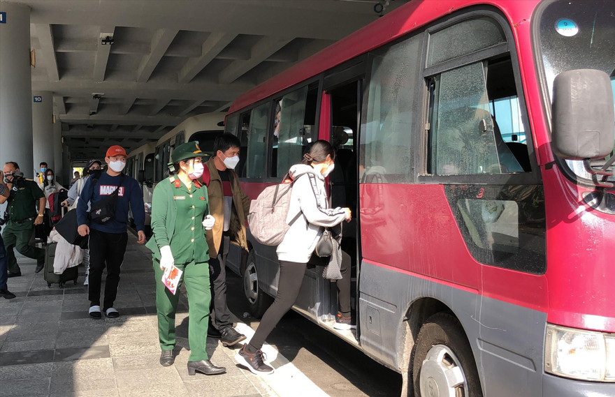Hành khách lên xe đến địa điểm cách ly sau khi xuống sân bay Cần Thơ. Ảnh: KIM HÀ 
