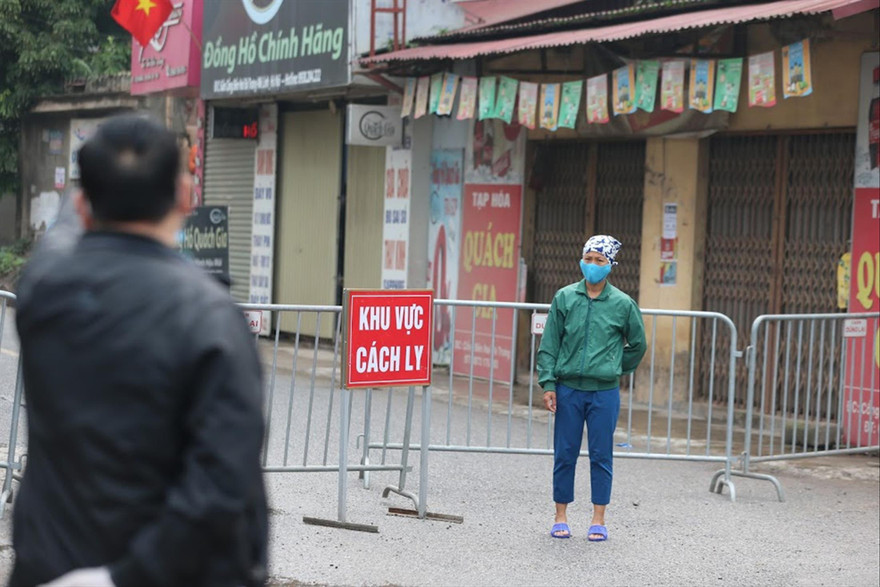 Một người dân được nhắc nhở khi đi qua khu vực cách ly thôn Hạ Lôi Ảnh: Hoàng Mạnh Thắng