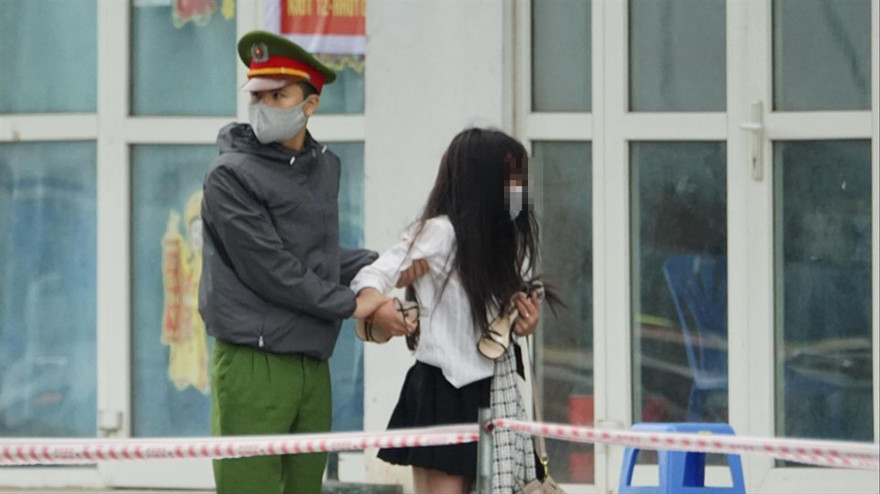 Cảnh sát đưa cô gái định trốn, trở lại nơi cách ly Ảnh: Mạnh Thắng