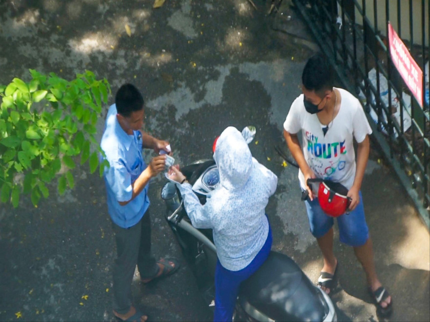 Nhân viên bảo vệ tại Tòa án Nhân dân quận Hoàng Mai thu 5.000 đồng/xe của người dân đến liên hệ làm việc Ảnh: Võ Hóa