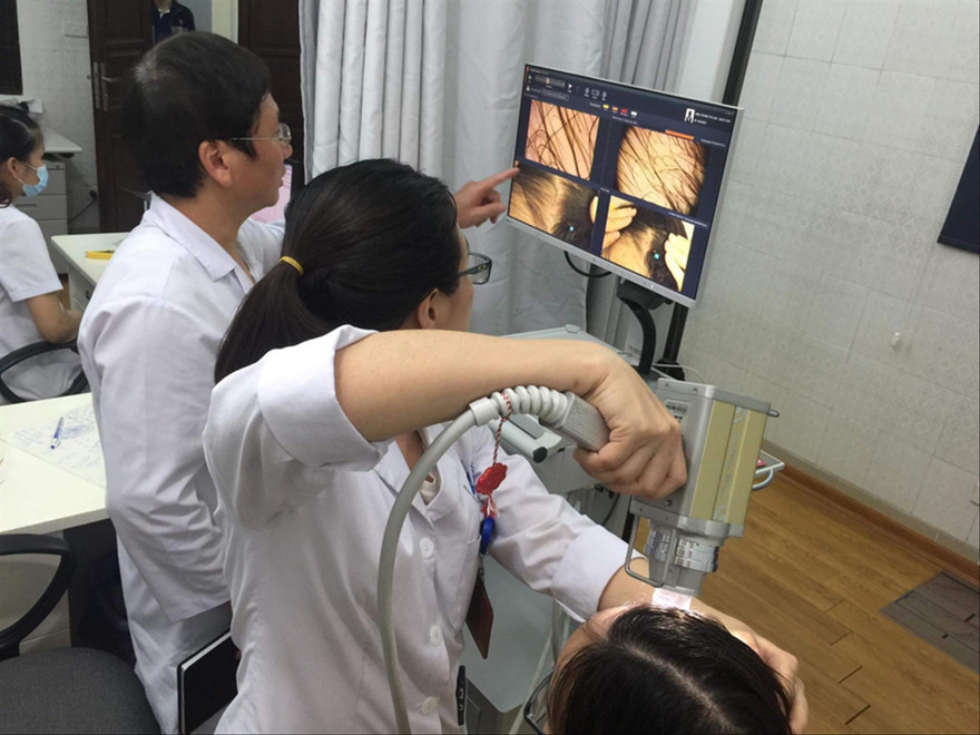 Bác sĩ BV Da liễu T.Ư kiểm tra nang tóc trước khi điều trị cho bệnh nhân