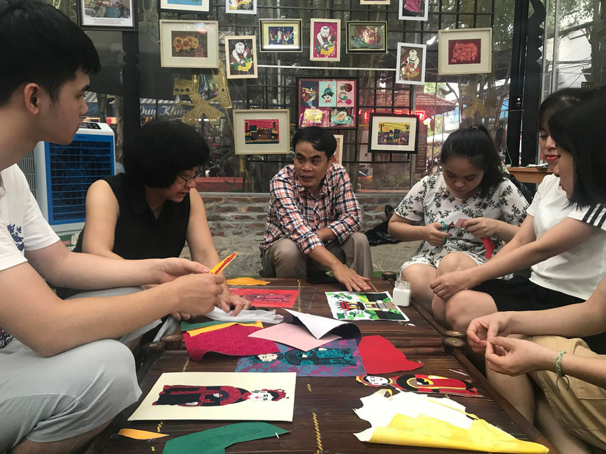 Anh Lê Việt Cường (áo sọc) và họa sĩ Đặng Thị Khuê (áo đen) hướng dẫn các bạn trẻ khuyết tật làm tranh ảnh Nhã Khanh