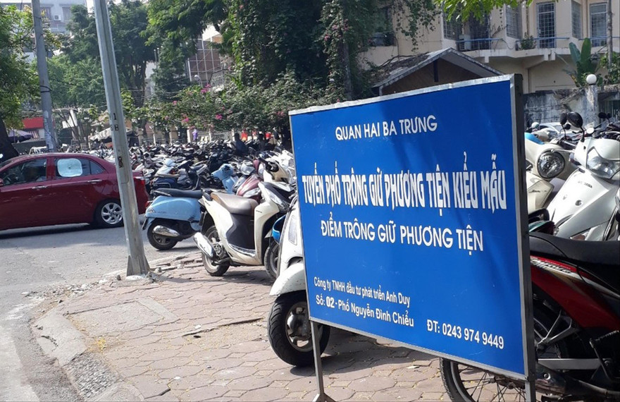 Trưng biển “Tuyến đường trông giữ phương tiện kiểu mẫu” nhưng điểm gửi xe trên phố Nguyễn Đình Chiểu chiếm gần trọn vỉa hè, thu tiền vé xe máy vượt 5.000 đồng/xeẢnh: Nguyễn Thắng