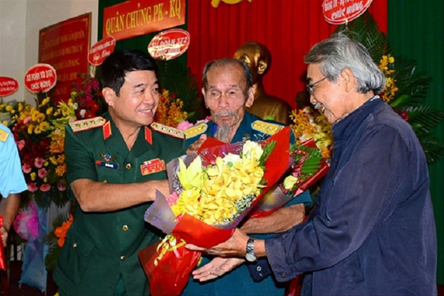 Thượng tướng Võ Văn Tuấn tặng hoa chúc mừng Anh hùng Nguyễn Văn Bảy và nhà văn Trúc Phương tại lễ ra mắt tập sách “Người Anh hùng chân đất”, tháng 4/2019