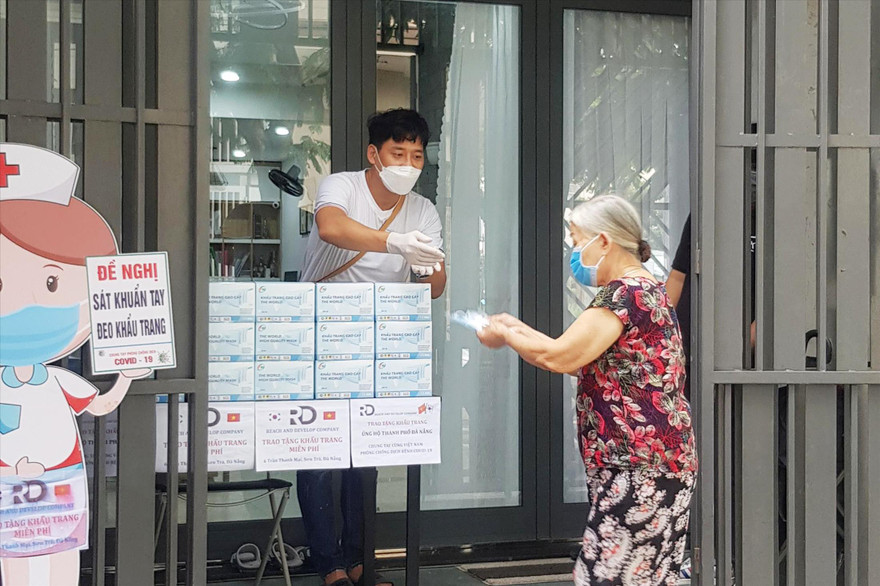Điểm phát khẩu trang, vitamin C miễn phí của anh Kim Won Hoon trên đường Trần Thanh Mại (phường An Hải Bắc, quận Sơn Trà, Đà Nẵng) trở nên quen thuộc với người dân khu vực này. Ảnh: Giang Thanh