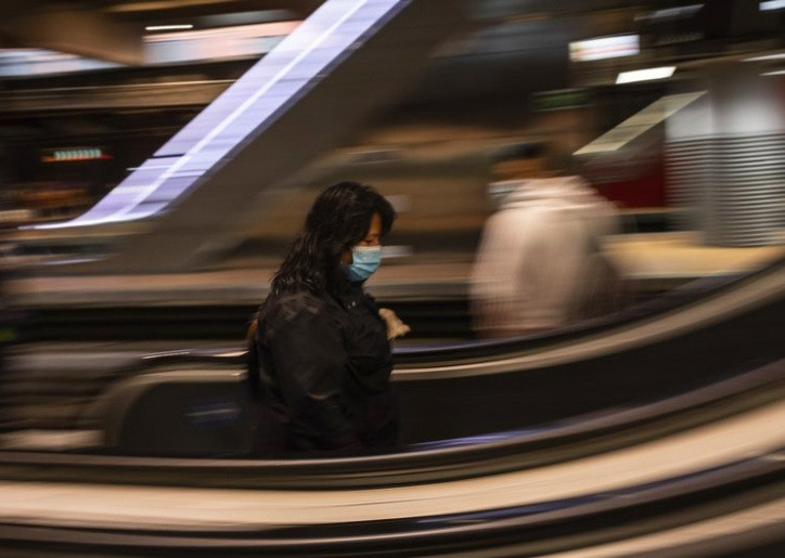 Một phụ nữ đeo khẩu trang khi đi trong ga tàu Atocha ở Madrid, Tây Ban Nha, ngày 13/4ảnh: AP