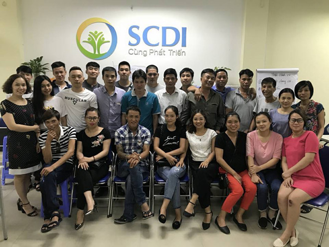 Hiệp (áo kẻ ca rô, ngồi hàng đầu) cùng các thành viên trong tổ chức SCDI 