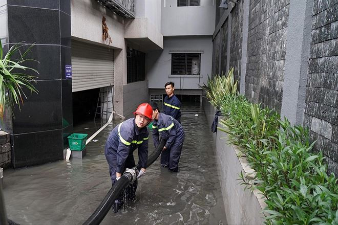Cảnh sát PCCC triển khai hút nước từ các hầm để xe chung cư Ảnh: Đình Du
