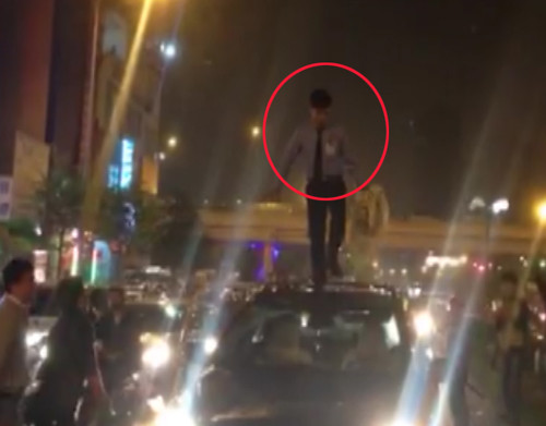 Nam thanh niên đứng trên nóc ôtô nhảy nhót. Ảnh cắt từ clip