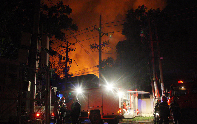 Khu vực bị cháy có một container hàng và cả trăm thùng hóa chất nên lửa bén nhanh, bốc cao hàng chục mét. Lửa cũng lan vào khu để xe của các công ty bên cạnh khiến công nhân phải tháo chạy. Ảnh: VnExpress