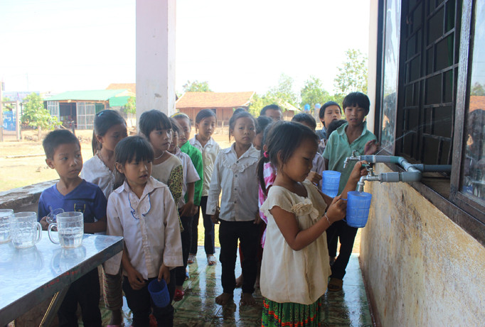 Học sinh uống nước tinh khiết miễn phí. Ảnh: H.T.