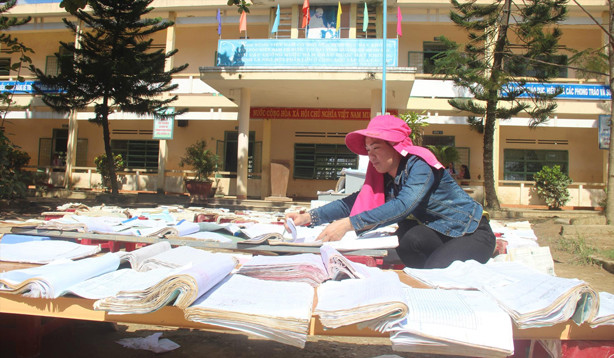 Thầy cô phơi sách vở bị nước mưa dầm ướt.