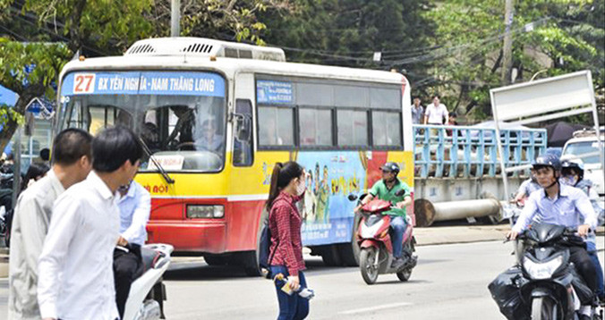 Người tham gia giao thông đi qua đường không có vạch kẻ đường, biển báo. Ảnh: Thanh Hà.
